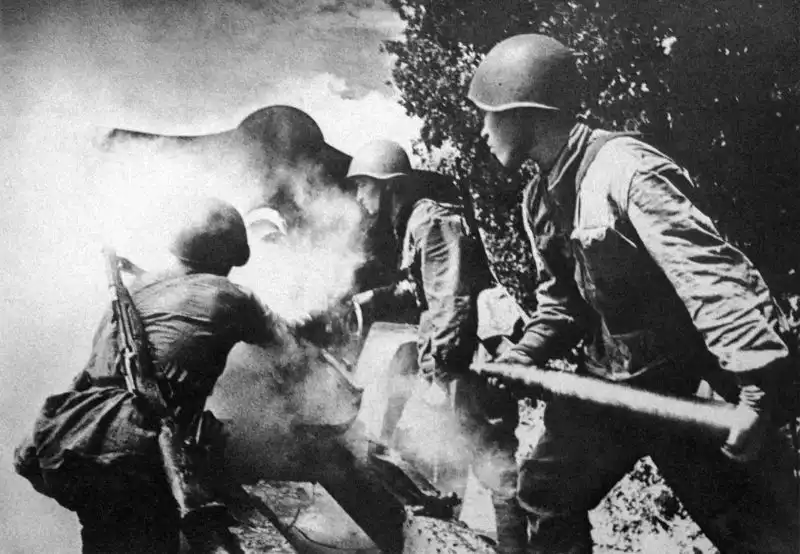 Historic photo of a Soviet 76 mm divisional gun M1939 (USV) firing at enemy positions during WWII. Captured in summer 1942 on the Southwestern Front by photographer Alexander Ustinov.