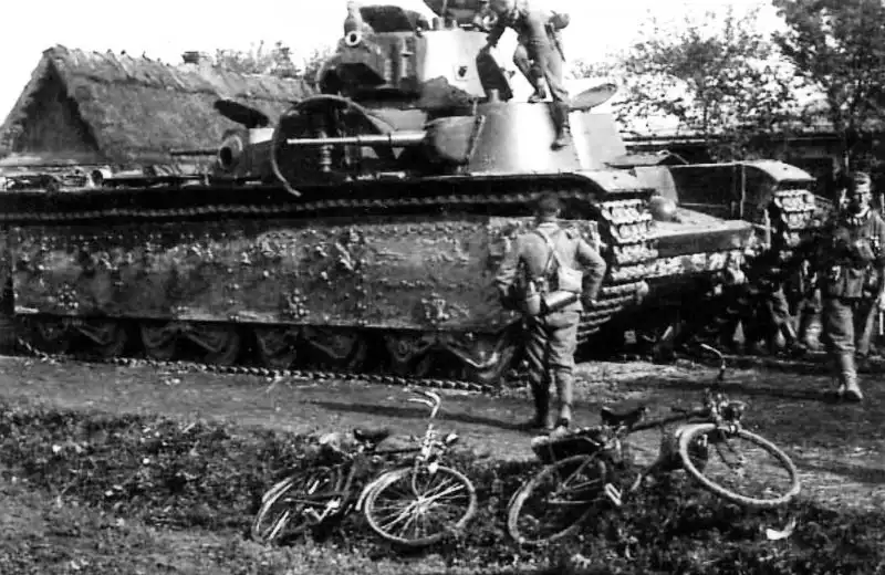 German soldiers inspect and photograph an abandoned Soviet T-35 heavy tank on a village street in western Ukraine during Operation Barbarossa, July 1941.