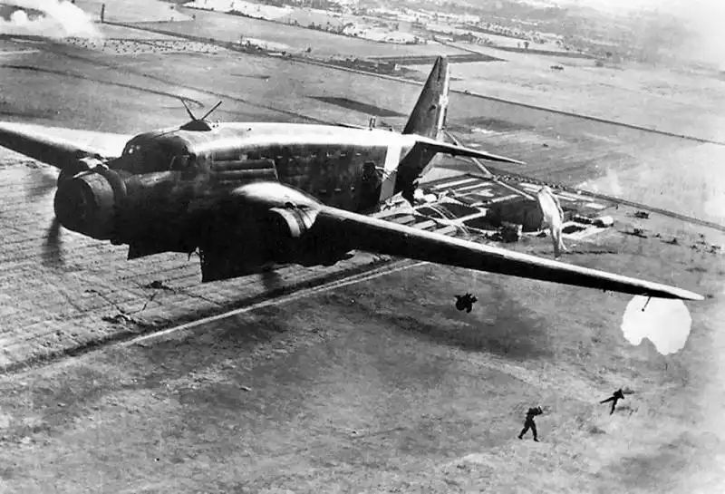 An Italian Savoia-Marchetti SM.82 military transport aircraft dropping paratroopers at extremely low altitude over fields in Albania in April 1939.