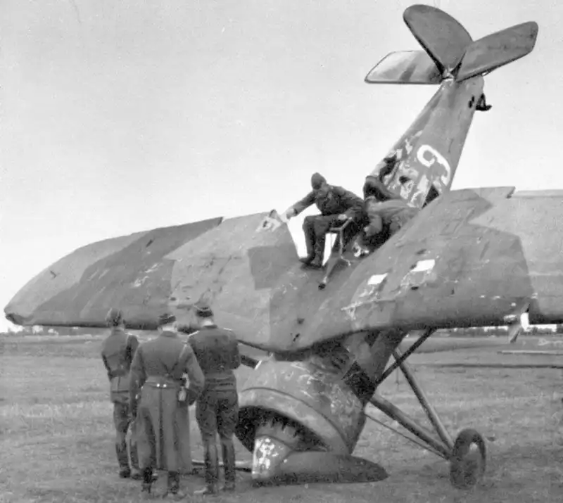 German soldiers examining a crash-landed Polish PZL P.11c fighter plane with retouched tail fins in Poland 1939.