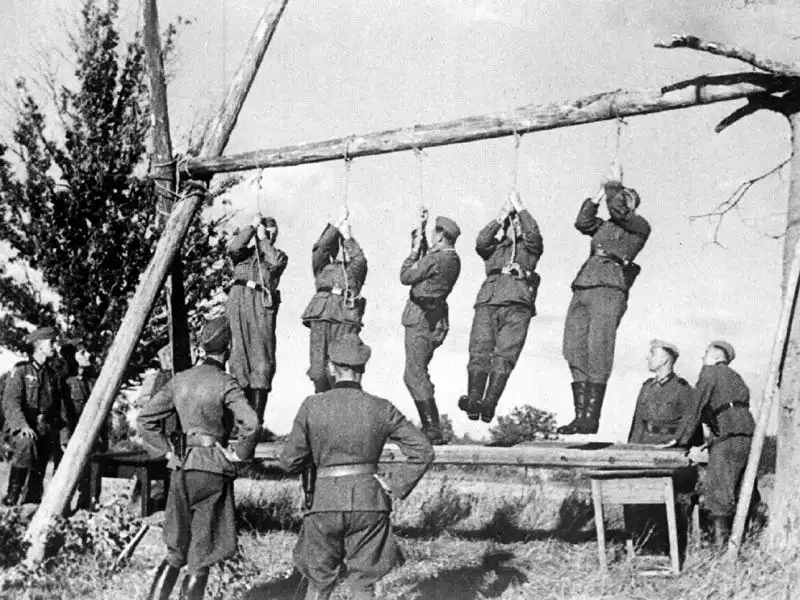 Captured German trophy photograph showing Wehrmacht soldiers testing gallows strength near Velizh Smolensk Oblast 1941.