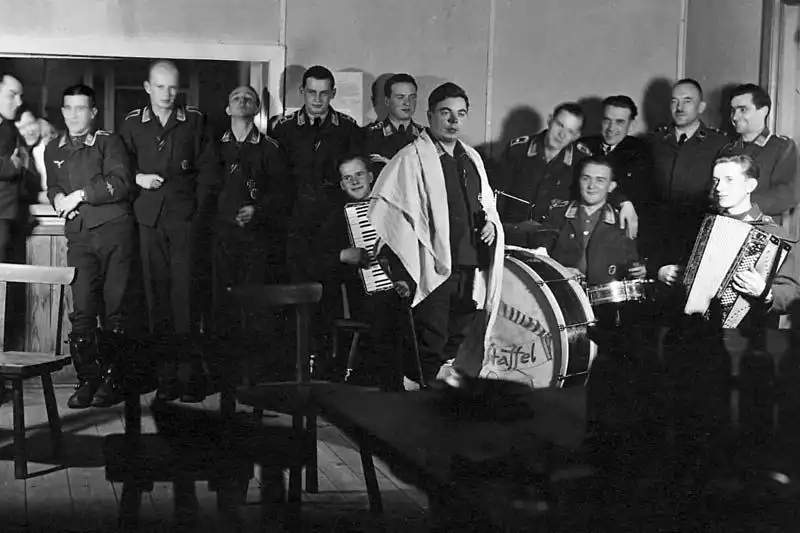 Luftwaffe airmen with accordions and drums performing for comrades in a squadron dayroom in Germany during the winter of 1944.