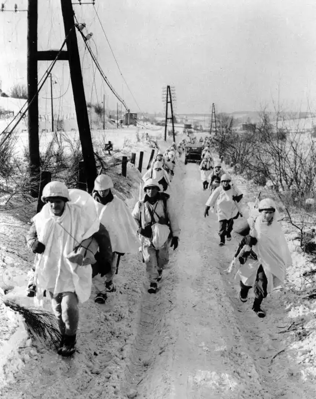 US soldiers of the 16th Infantry Regiment wearing improvised winter camouflage suits near Faymonville in 1945.