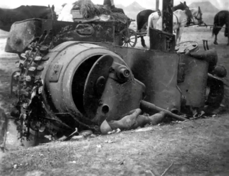 Destroyed Soviet BA-10 armored car overturned in a ditch beside the burned remains of a Red Army crewman during 1941 on the Eastern Front