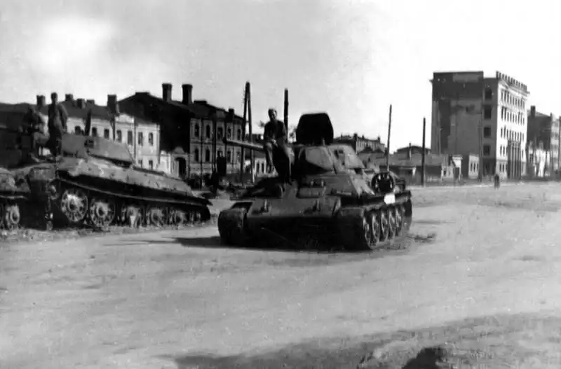 German soldiers sitting on knocked-out Soviet T-34 medium tanks on a city street in Voronezh during summer 1942 battles.
