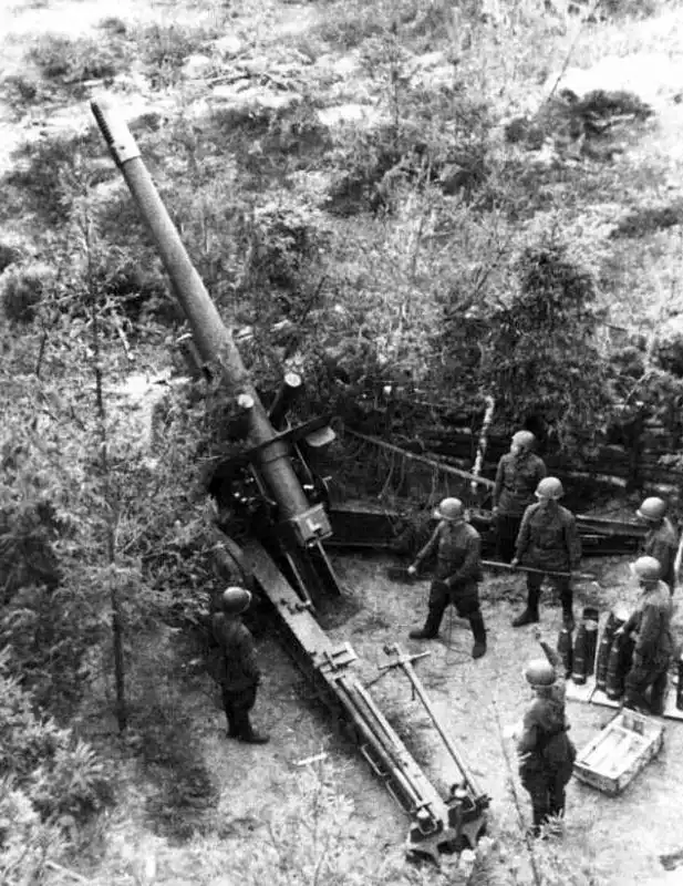 Soviet artillery crew operating a 152mm ML-20 gun-howitzer set at maximum elevation in a forest position on the Volkhov Front in 1942.