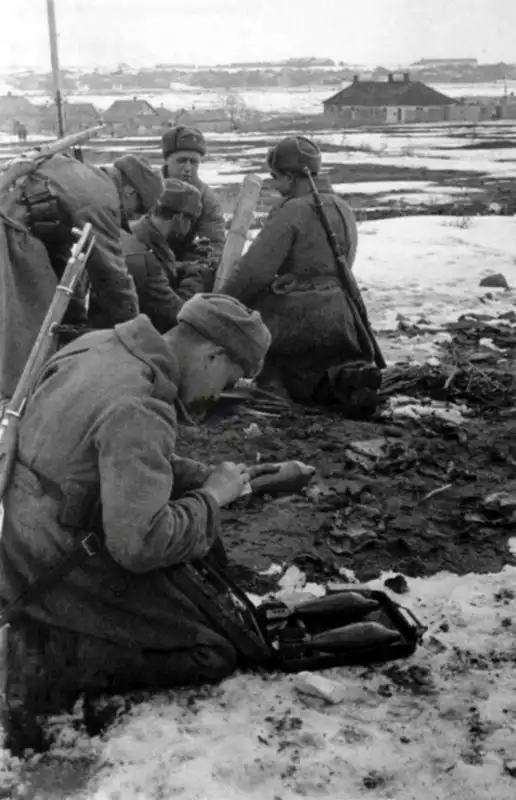 Soviet mortar crew in winter uniforms preparing 82 mm O-832 mortar rounds from a transit box near Kursk in February 1943, photographed by Emmanuil Evzerikhin.