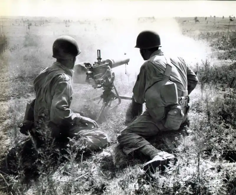 American soldiers operating a Browning M1917A1 water-cooled heavy machine gun during military exercises in Louisiana, 1942.