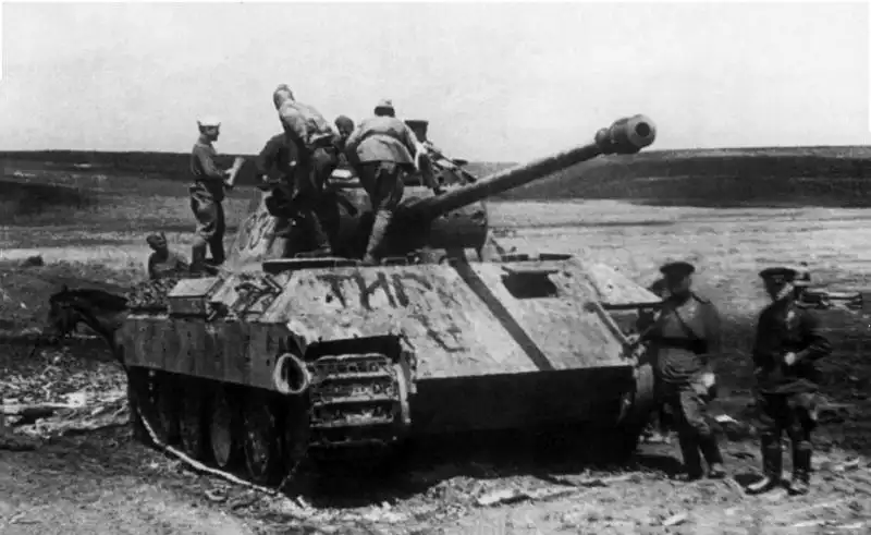 Alt Text: Soviet soldiers inspecting a knocked-out German Panther Ausf. D tank during the Battle of Kursk in the summer of 1943.