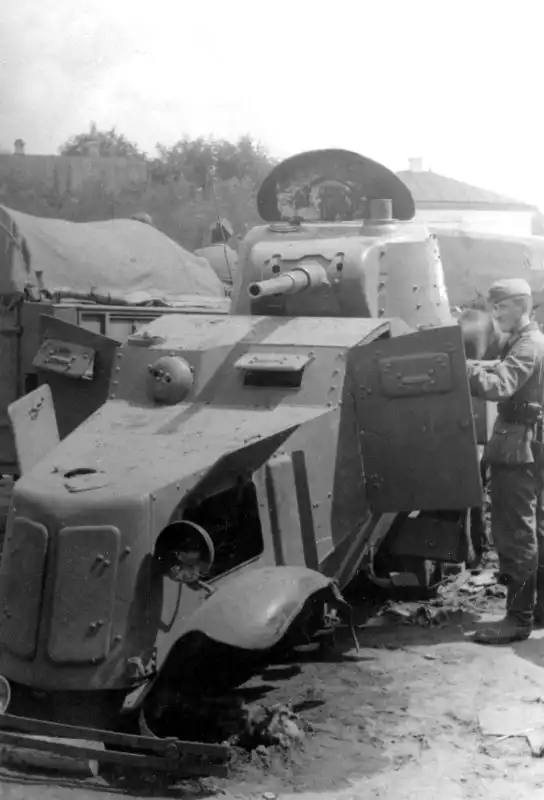 Captured Soviet BA-10 armored car on the Eastern Front, 1941, showing a German soldier inspecting the damaged Soviet armored vehicle.