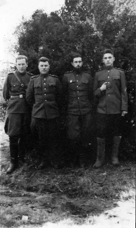 Black and white historical photo showing four senior Soviet Red Army tank officers in uniform standing together in a pine forest, April 1945.