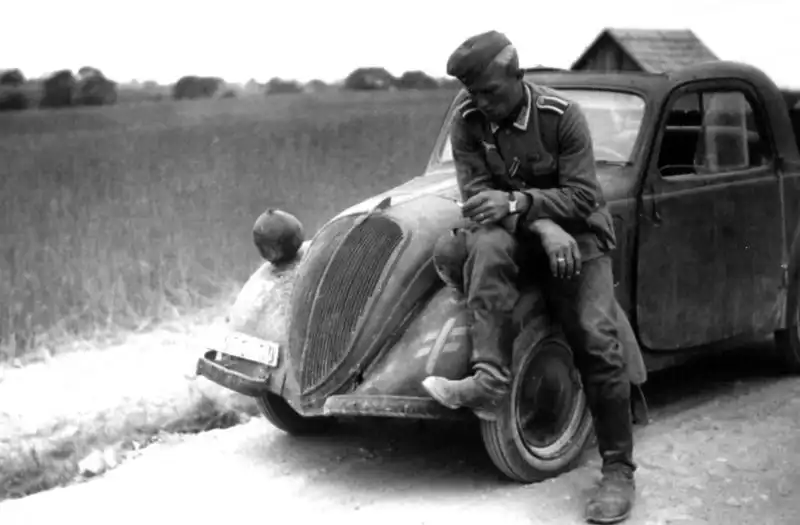German driver sitting on the fender of a FIAT 500-type light car used by the Wehrmacht on the Eastern Front, summer 1943.