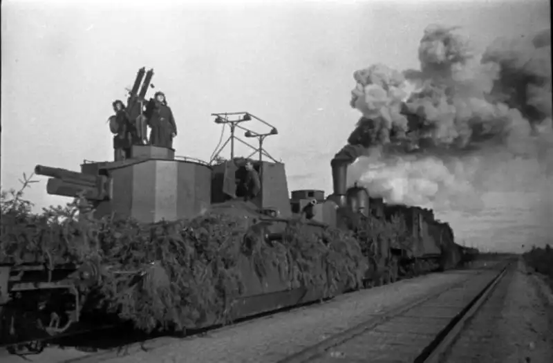 Camouflaged Soviet armored train with twin Maxim anti-aircraft machine guns and D-2 armored railcar during 1941