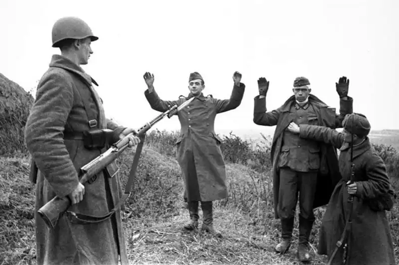 German Wehrmacht soldiers surrendering with hands raised to Red Army troops armed with SVT-40 rifles near Tula 1941.