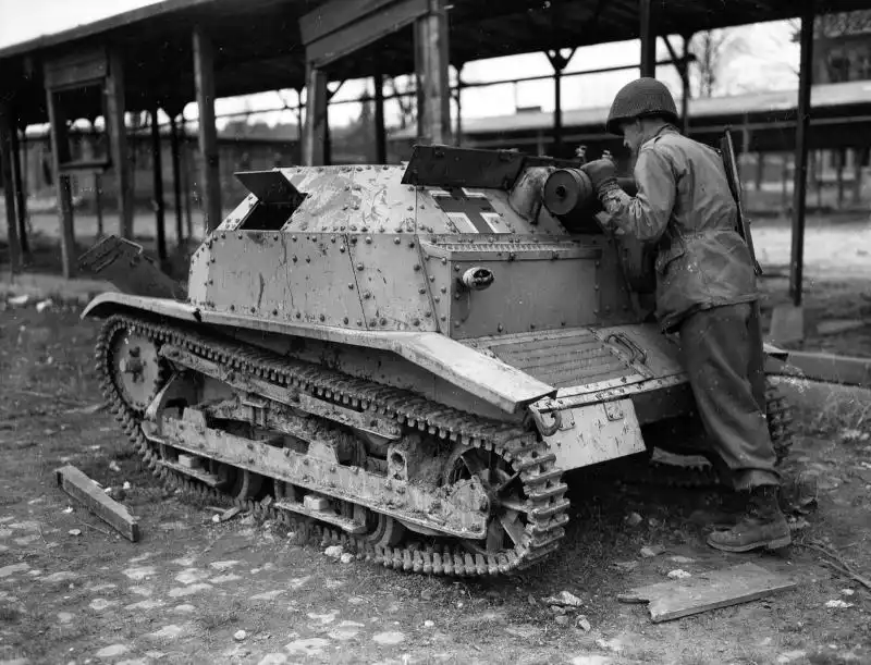 US soldier inspecting a captured Polish TKS tankette bearing German Balkenkreuz markings in France 1944.