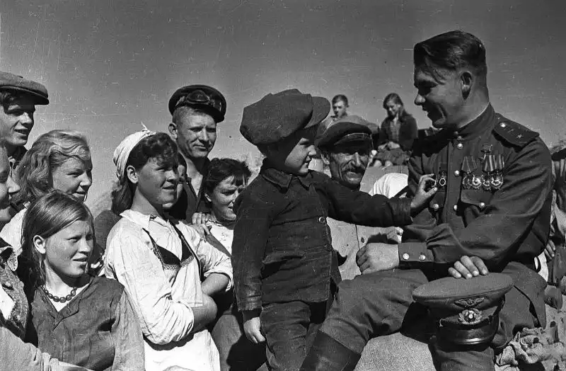 Soviet fighter ace Maj. Nikolai Pinchuk, Hero of the Soviet Union, speaking with villagers at his home collective farm in Belarus, 1945.