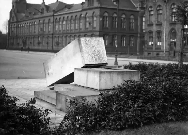 Black and white historical photo from NAC showing a broken stone monument block lying on a square in front of a municipal building in Bohumín, 1938.