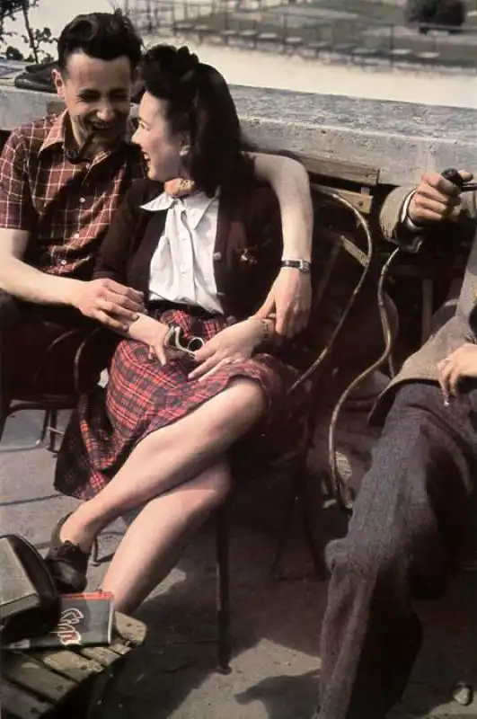 Young French couple embracing on a bench in the Luxembourg Garden in occupied Paris during World War II, 1943 color photograph