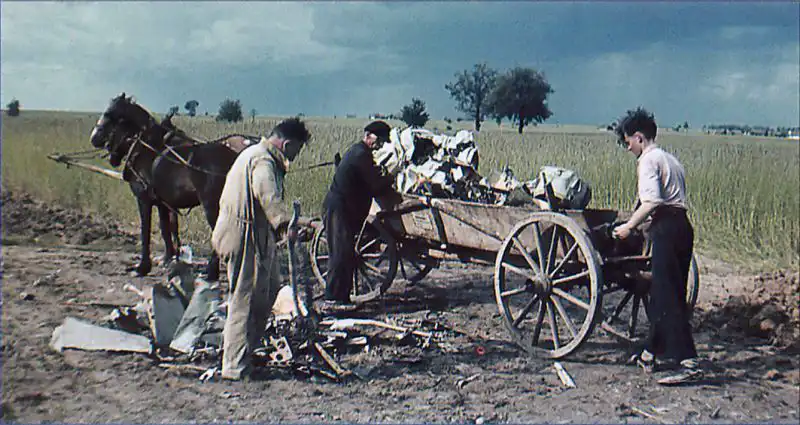 Workers loading wreckage of a crashed German Bv 143 guided missile onto a horse-drawn cart at Peenemünde, 1941.