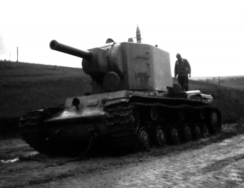 Abandoned Soviet KV-2 heavy tank with towing cables, likely left behind after a breakdown during the early stages of the German invasion. A 152mm shell is visible atop the turret