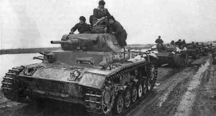 A column of German Pz.Kpfw.III and assault guns StuG III armored vehicles