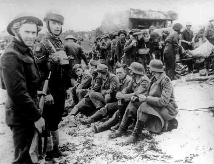 Canadian paratroopers guarding German prisoners at Juno Beach