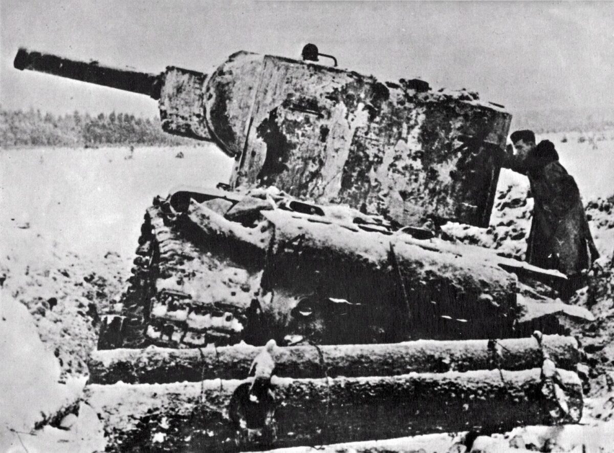 A German soldier inspects a damaged Soviet KV-2 tank