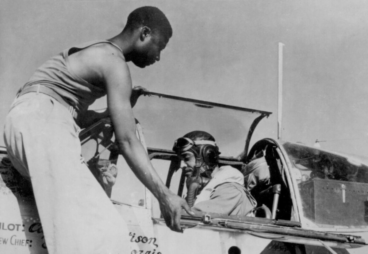 American aviation technician Alfred Norris assists the pilot of William T. Mattison